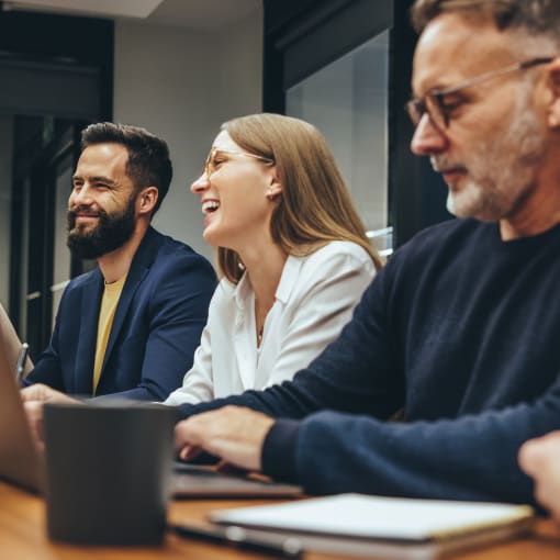 Four people sit at a conference room table.