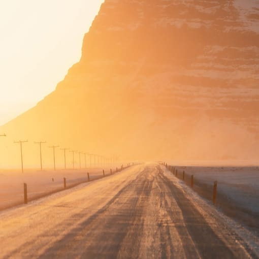 Empty road extends toward mountain.