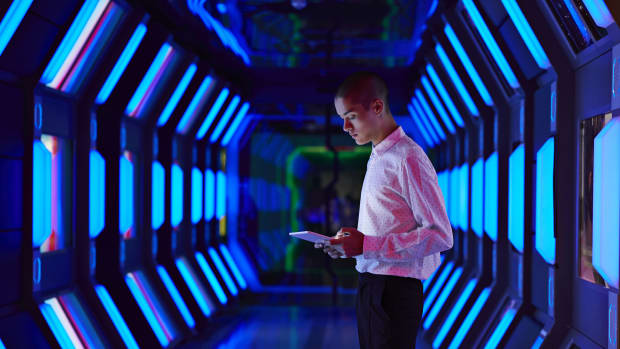 Person in futuristic technology facility looking at digital tablet