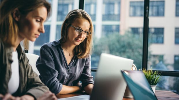 Two female colleagues looking at a laptop