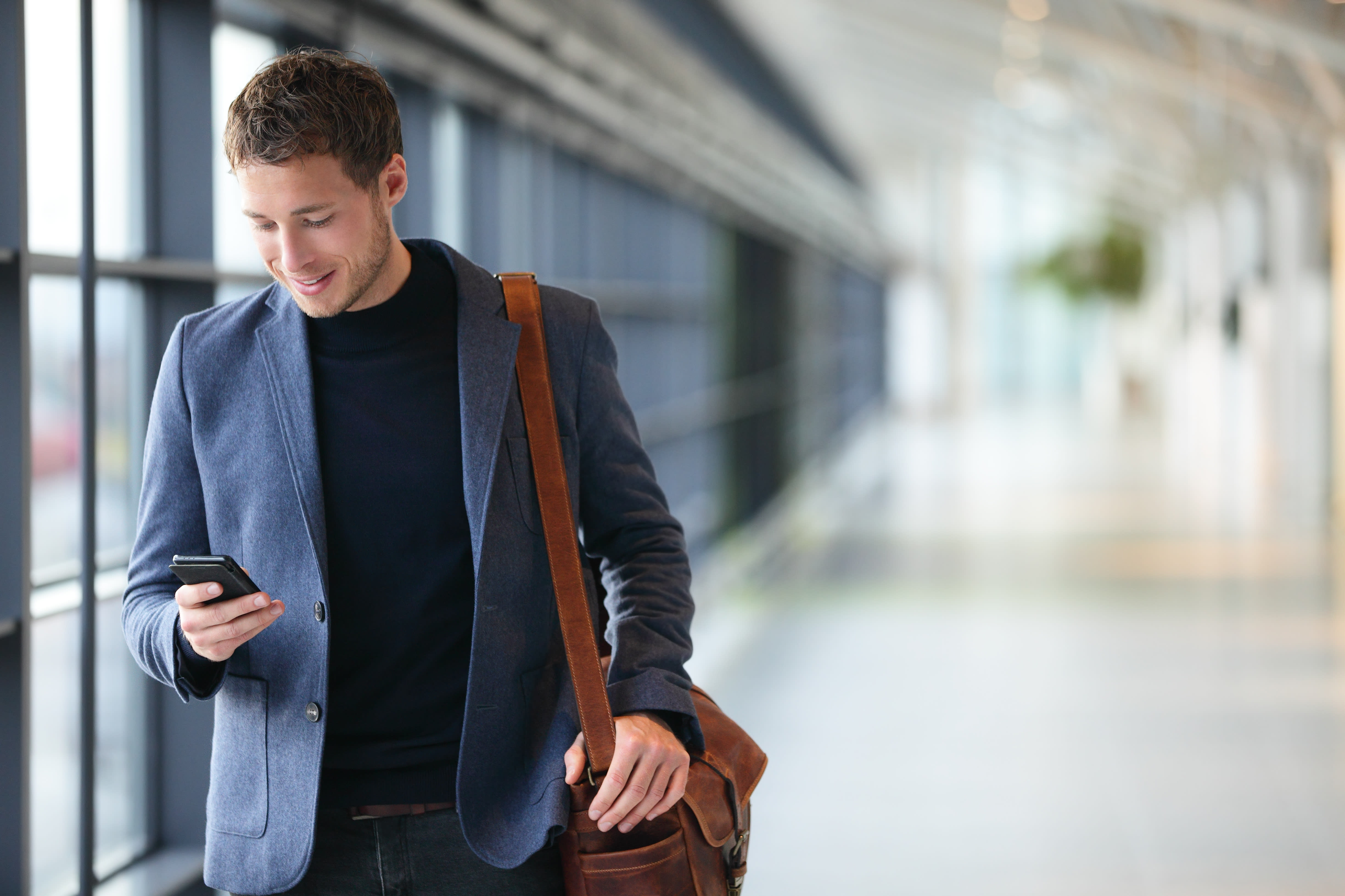 A man is smiling at his phone