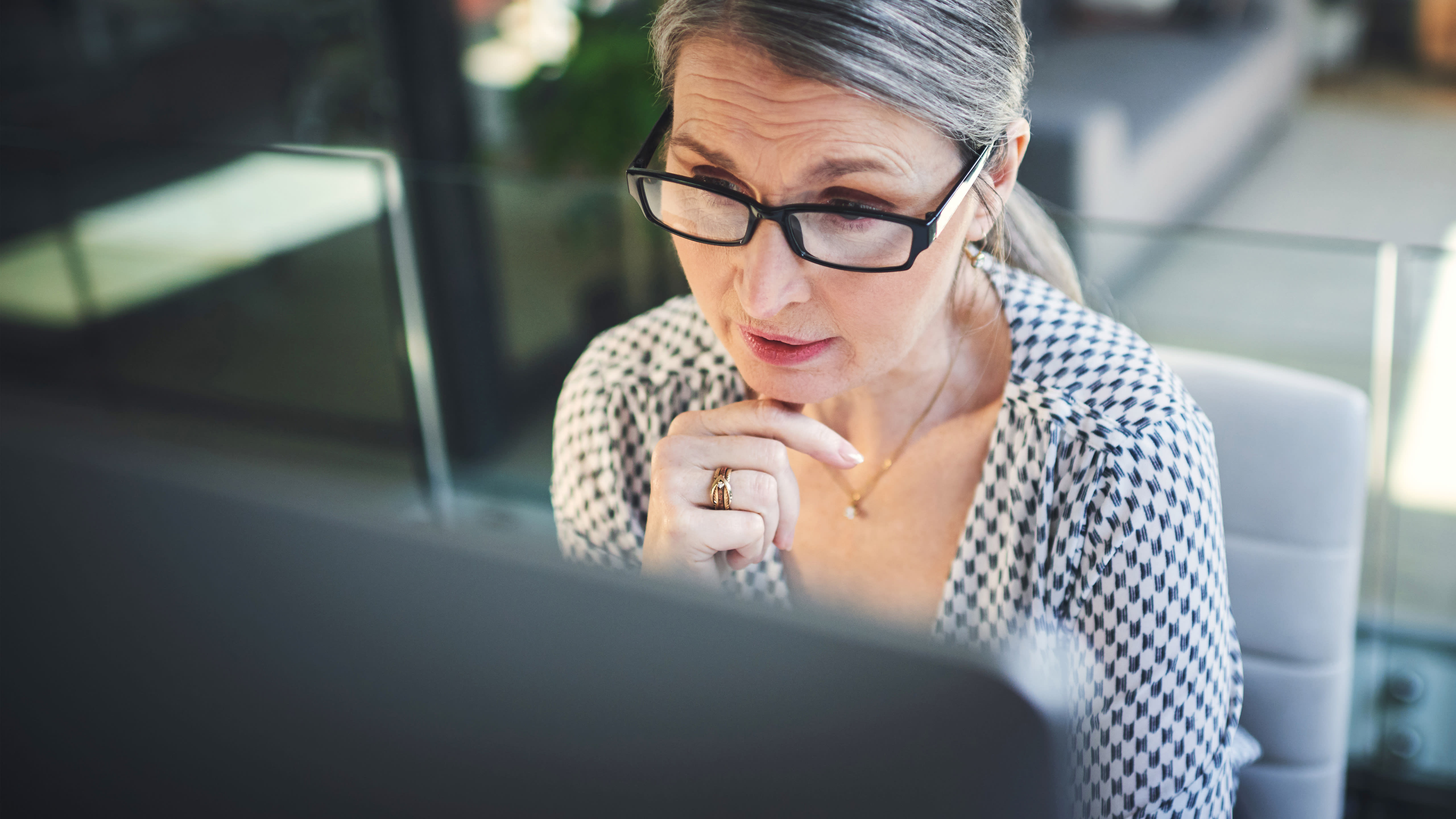 Business woman with glasses looking at a computer screen