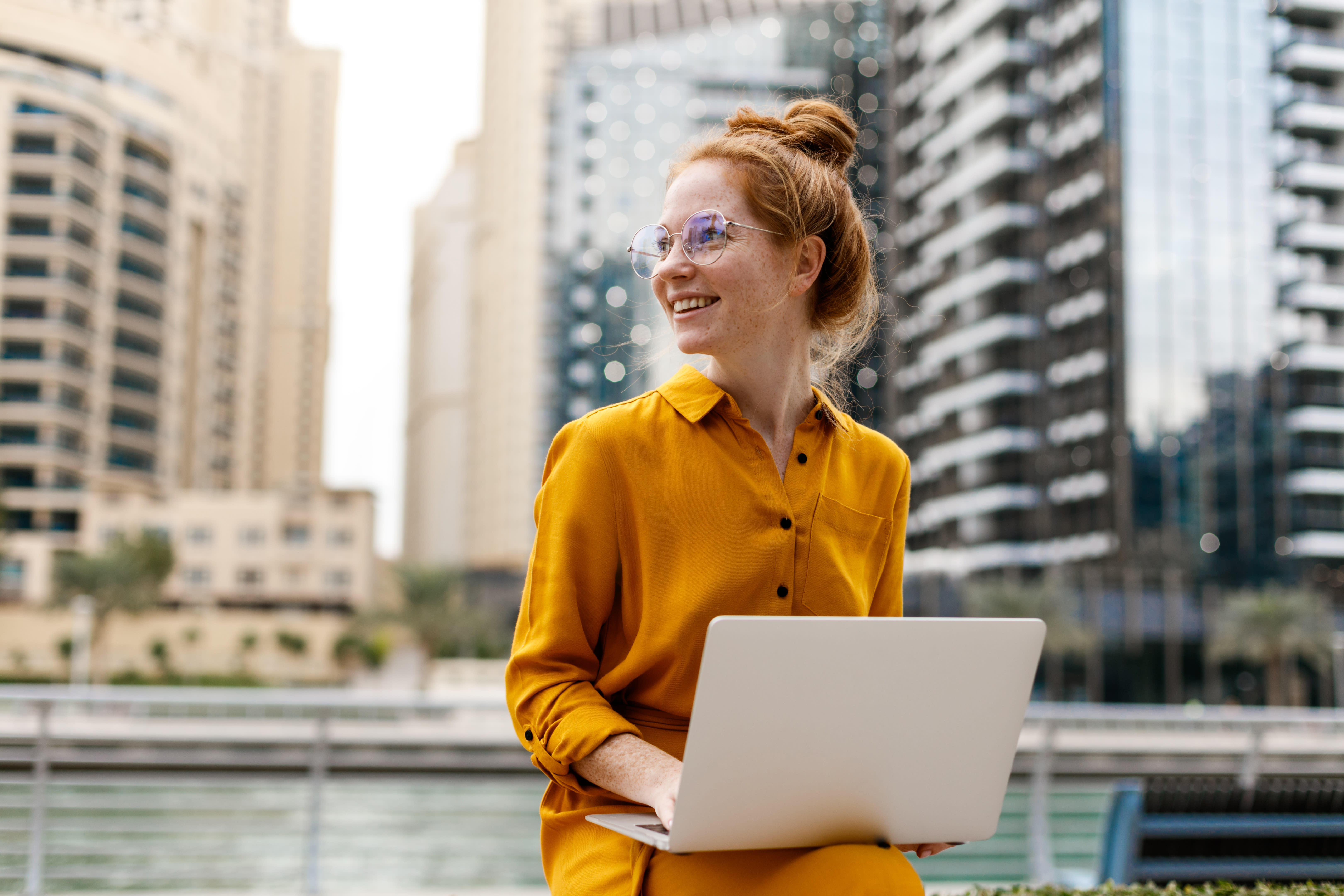 Young woman sitting outside and working on laptop