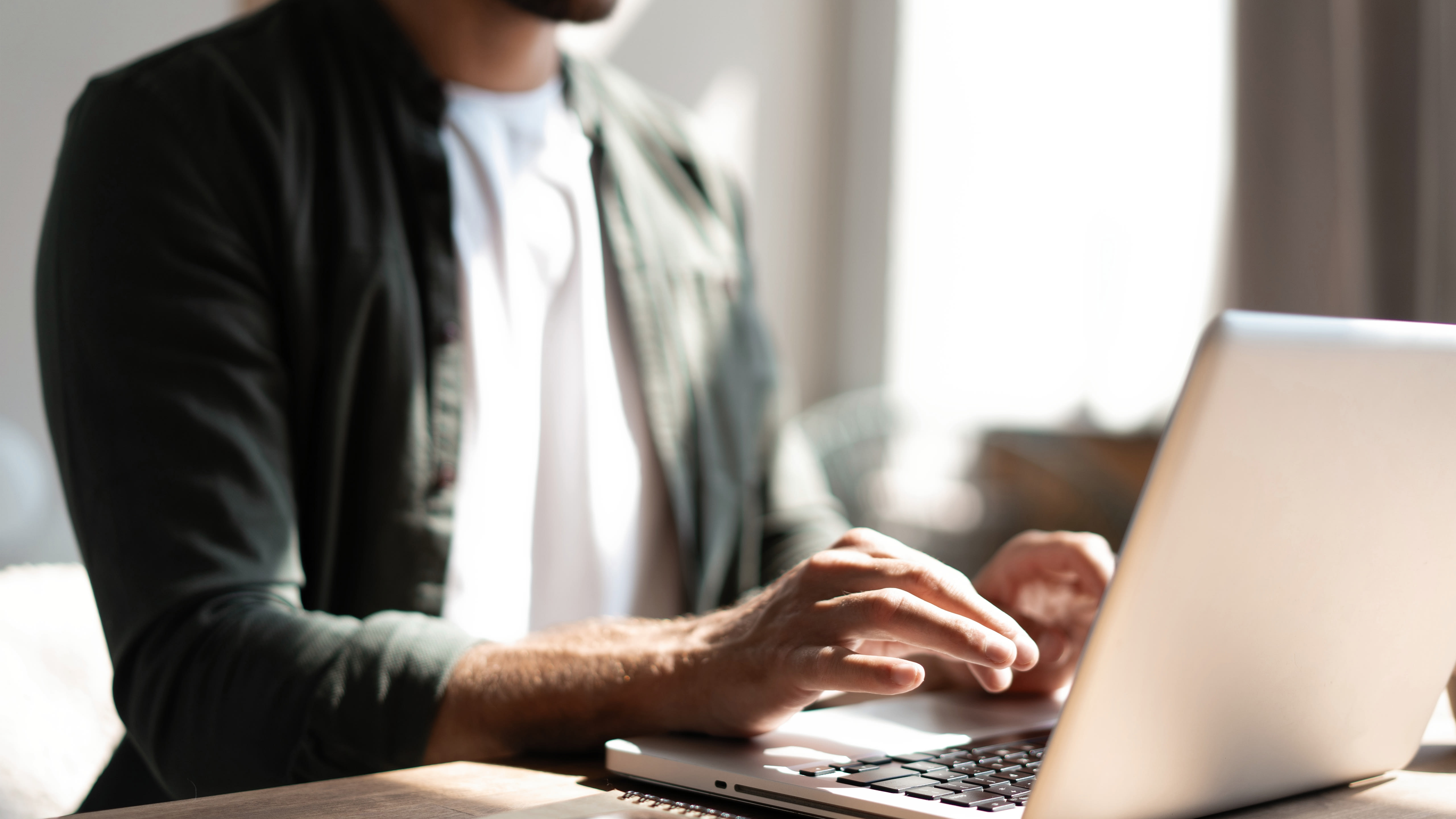 A person enters their information on a laptop to watch an on-demand webinar.