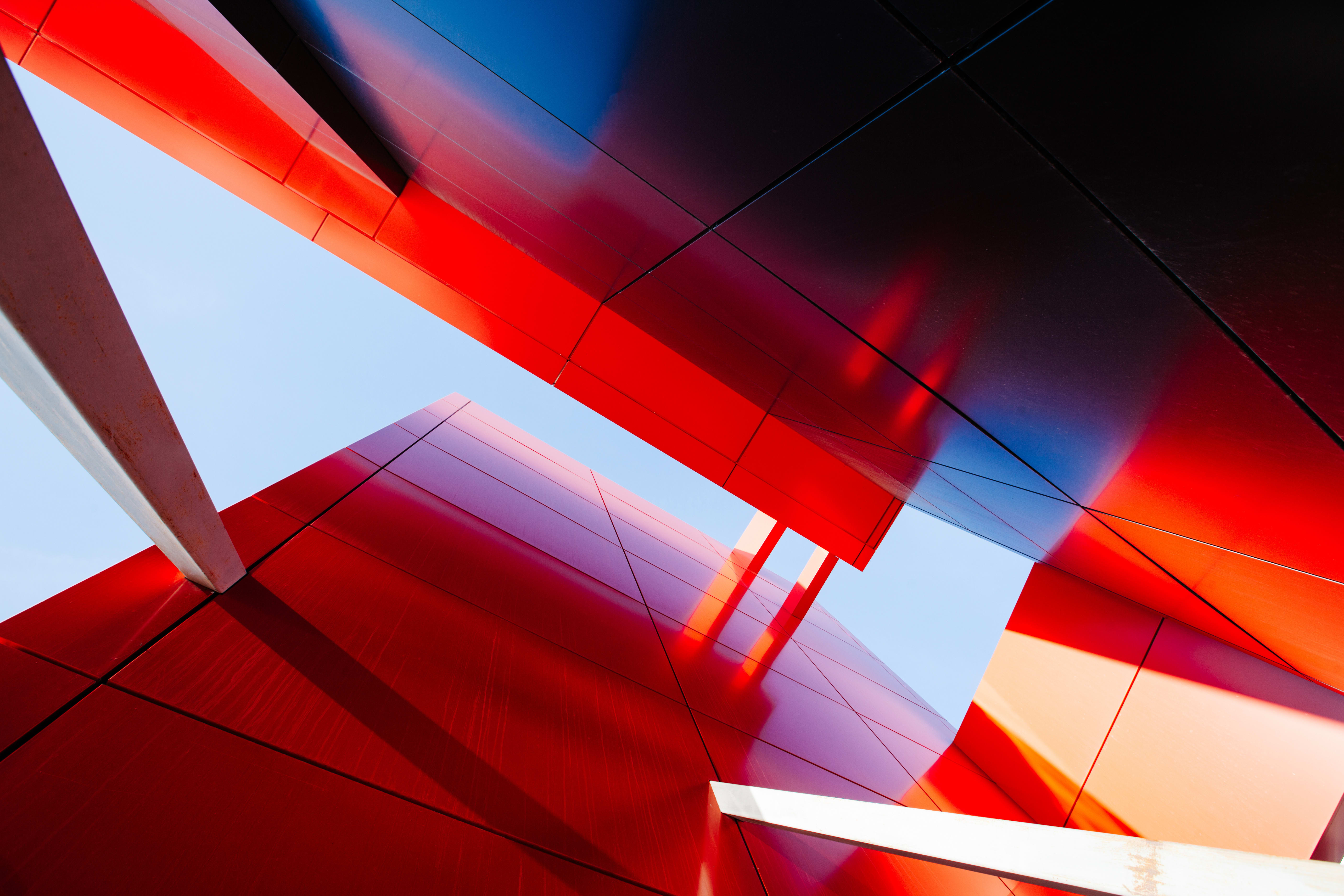 A low-angle shot of steel skyscrapers, reflecting bright orange hues.