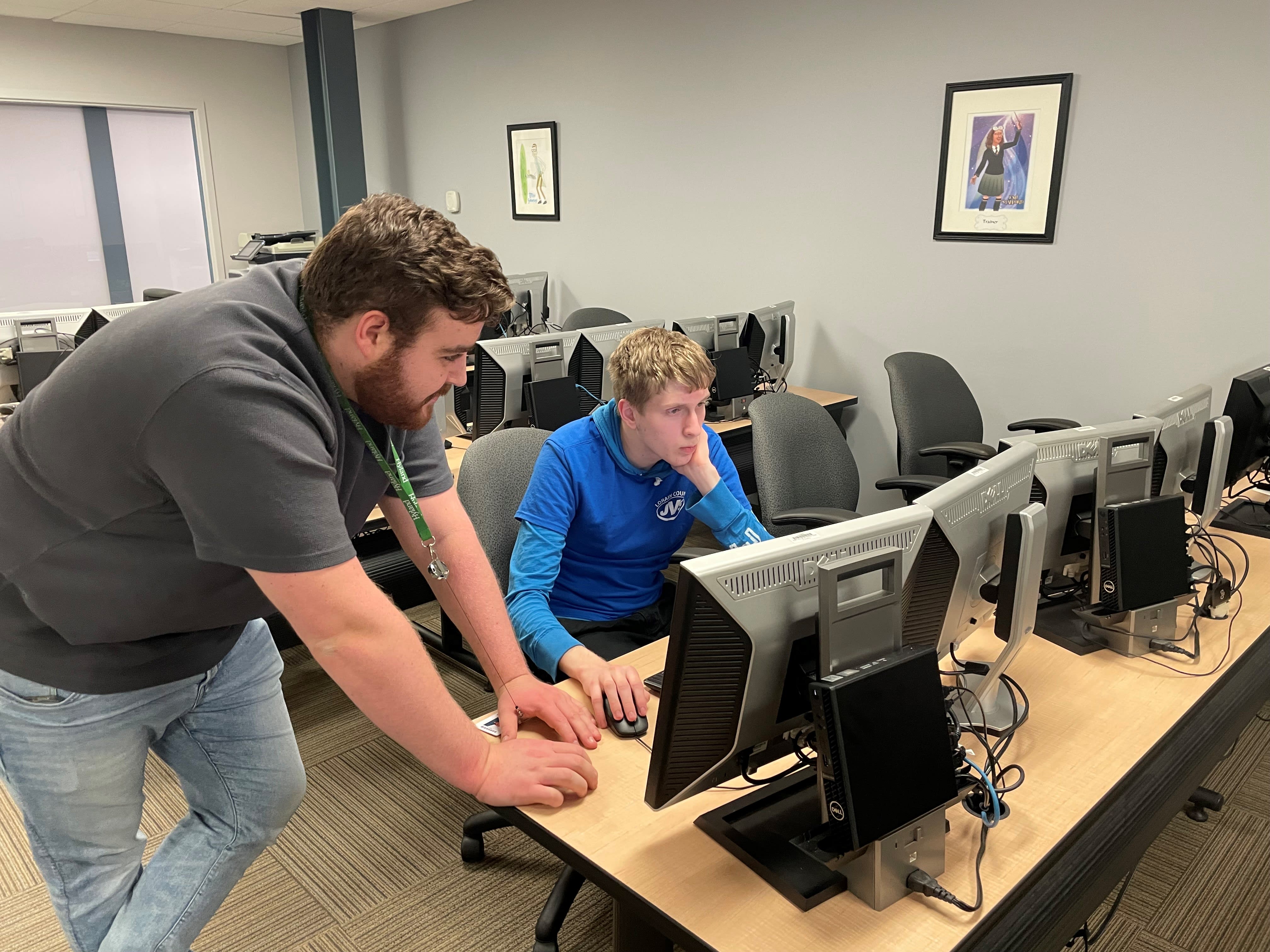 Hy-Tech Club instructor reivewing code with a student on a computer monitor