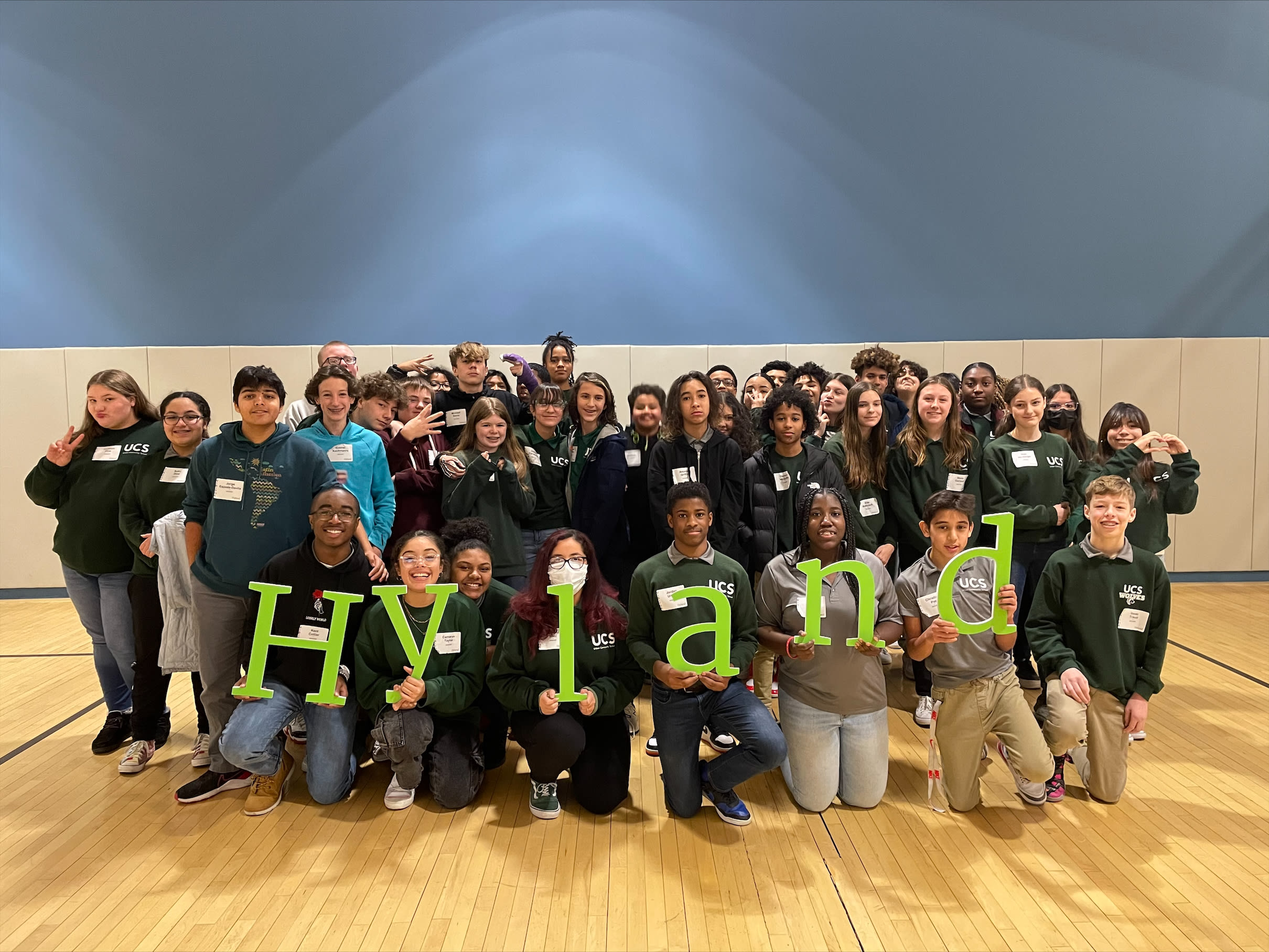 Tech Outreach eigth graders holding up a Hyland sign