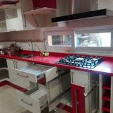 cocina con puertas posformadas rectas y cubierta cuarzo rojo aperlado