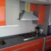 cocina naranja con cubierta cuarzo negro y gris galaxy