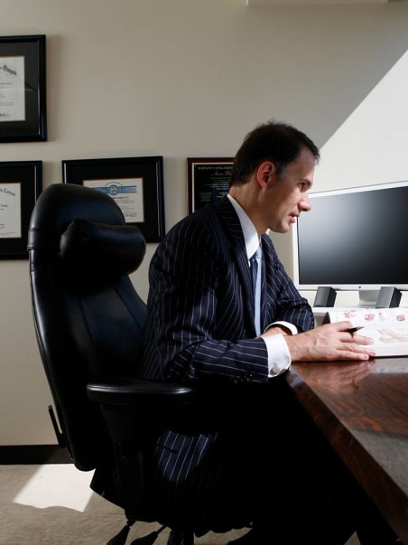 Dr. Aaron DeShaw at desk with book