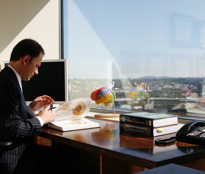 Dr. Aaron DeShaw at desk with book