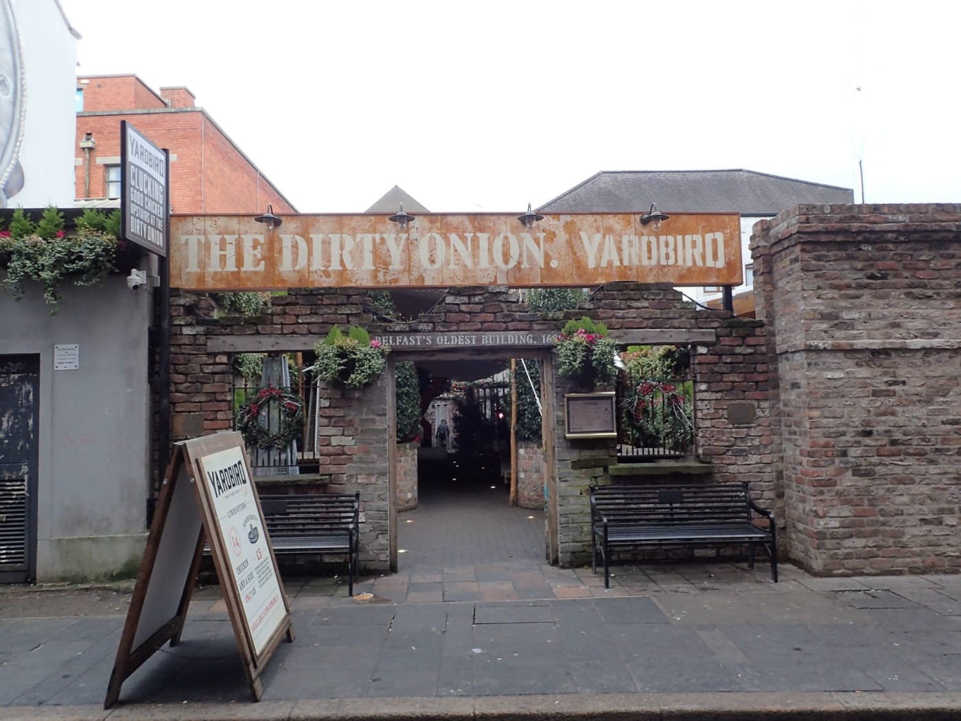 The entrance of The Dirty Onion pub, with brick walls and benches, in Belfast's Cathedral Quarter