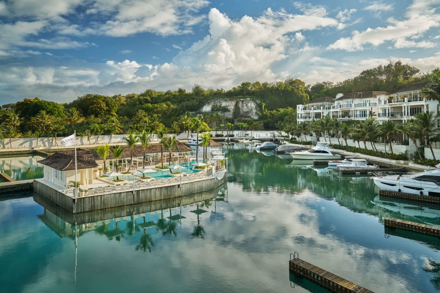 La piscina de la marina del Pendry Yacht Club en Pendry Barbados, rodeada de yates amarrados