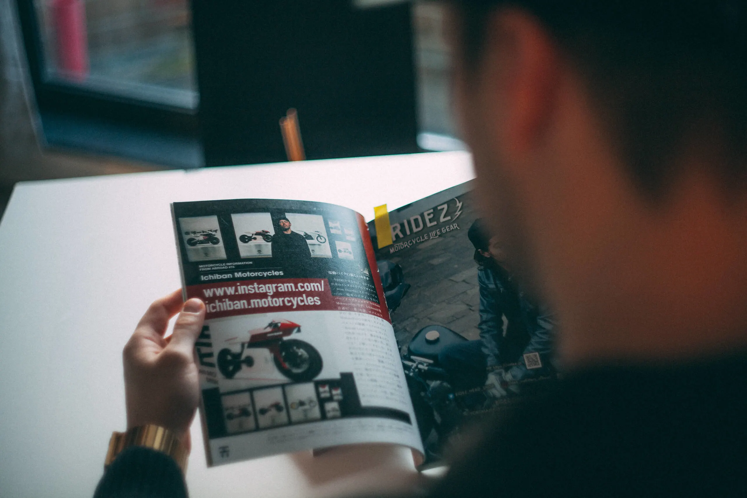 A man reading a magazine talking about ichiban motorcycles
