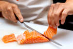 a chef slicing raw salmon for sushi | Classpop Shot