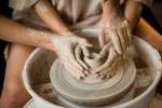 a couple shaping pottery on the wheel Shot