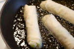 spring rolls frying in hot oil Shot