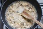 stirring mushroom risotto on the stove with a wooden spoon Shot