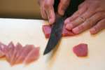 chef's hands slicing fresh tuna Shot