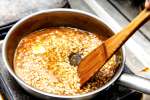 stirring risotto in a pan with butter Shot