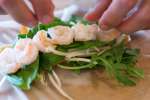 chef wrapping shrimp and vegetables in a rice paper wrapper Shot