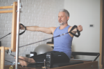 Houston - man doing arm workout on reformer.png