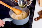 pouring broth into rice to make risotto | Classpop Shot