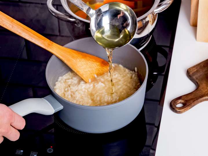 pouring broth into rice to make risotto | Classpop Shot