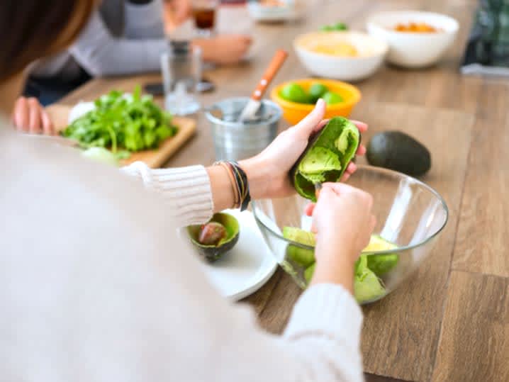 woman using avocado to make guacamole | Classpop Shot