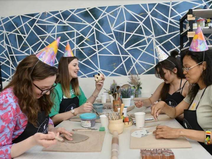 women celebrating in a pottery class Shot