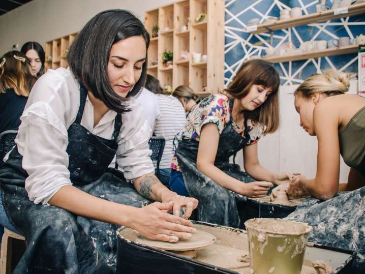 women doing pottery on a wheel Shot
