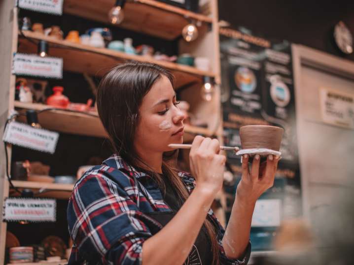 a woman painting a pottery vase Shot