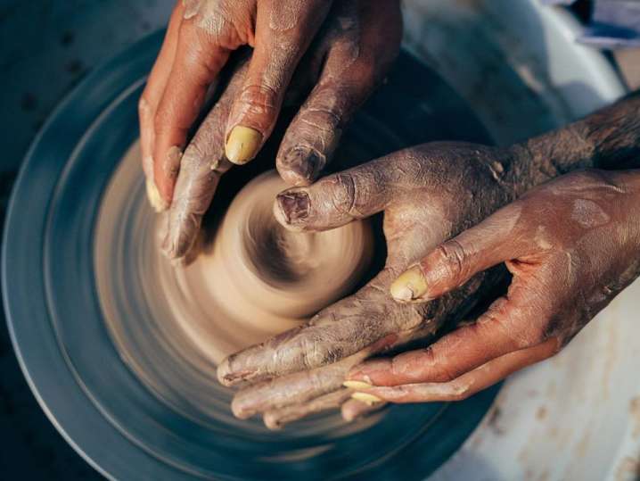 fours hands shaping pottery Shot