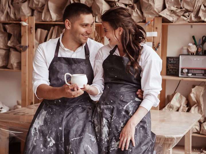 a couple laughing in pottery class Shot