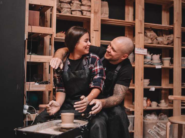 a couple shaping pottery on wheel Shot