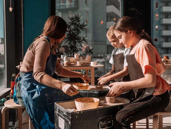 a pottery instructor and two kids doing pottery Shot