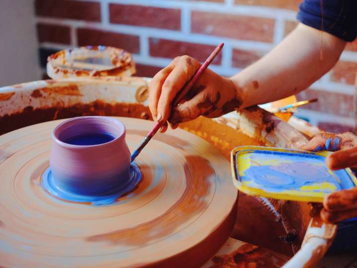 a woman painting a pottery vase Shot