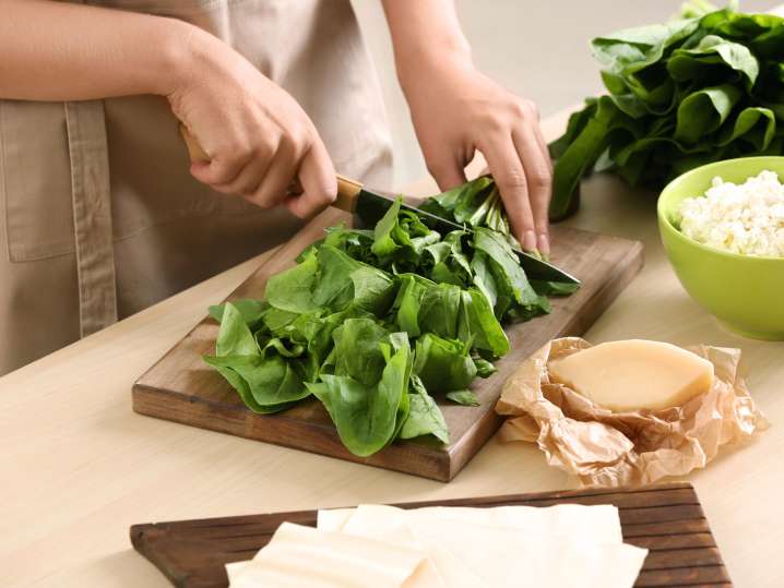 Cutting spinach and making the pasta filling Shot