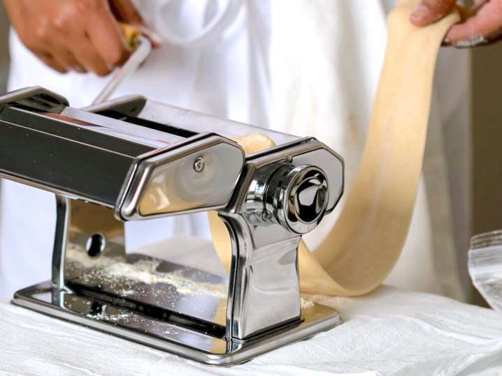 Rolling pasta dough with pasta machine Shot