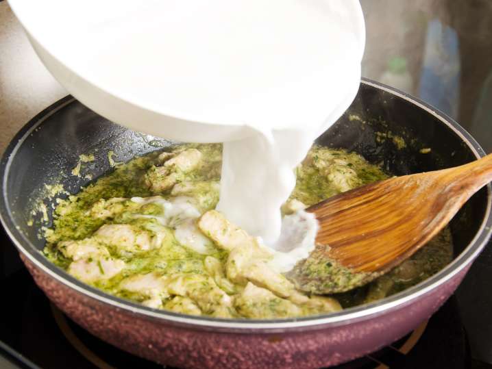 Adding coconut milk to curry Shot