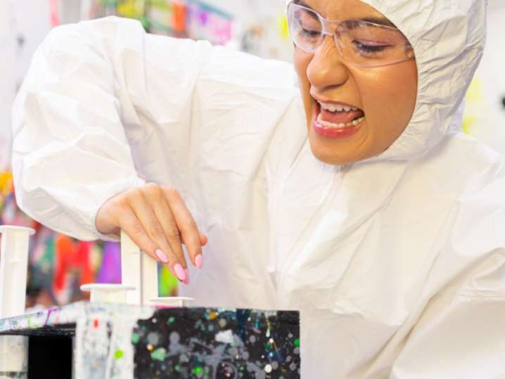 Houston - a woman in a woman shooting paint in an art team building activity Shot