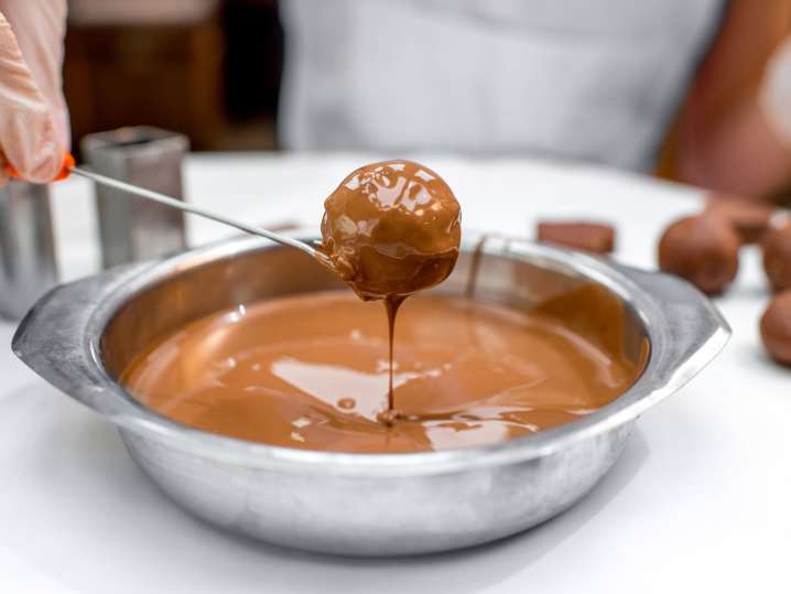 Indianapolis - a person dipping a chocolate in caramel Shot