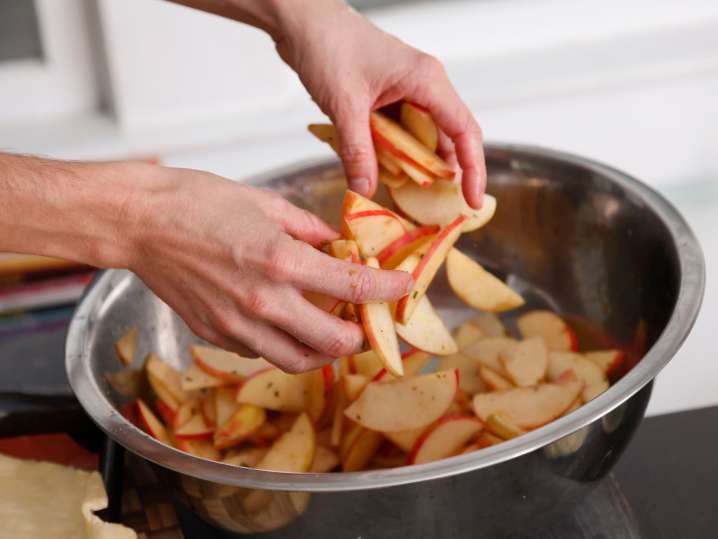 London - a woman moving pieces of apples in a bowl Shot