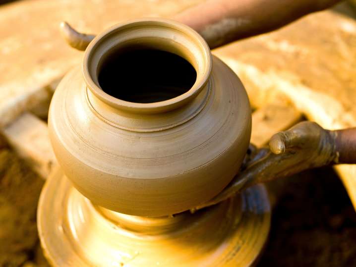 a woman making pottery on the wheel Shot
