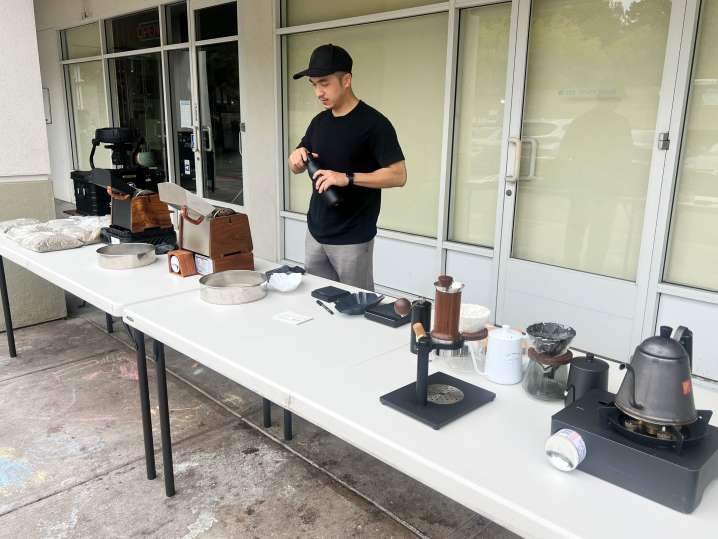 Bay Area - Instructor preparing equipment at an outdoor coffee roasting class setup with multiple roasting stations Shot