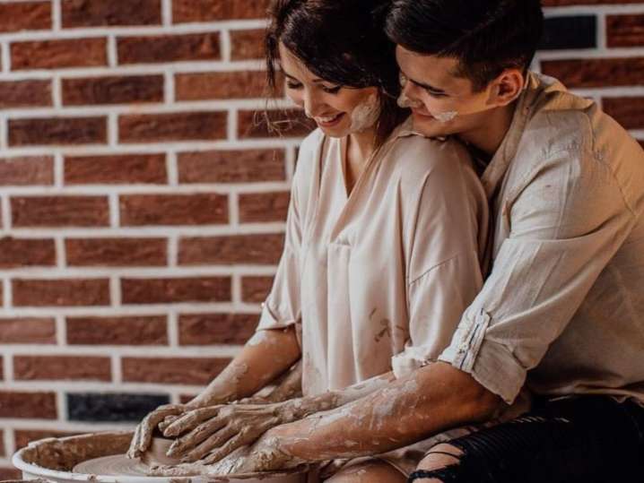 Chicago - Romantic couple sitting close together while shaping clay on a pottery wheel Shot