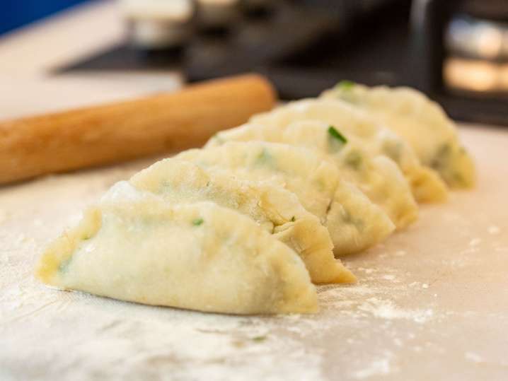 Boston - Homemade dumplings arranged in a row on a floured countertop next to a rolling pin Shot