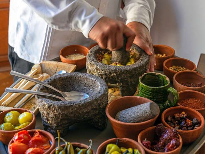 Boston - Chef presenting an assortment of ingredients for making guacamole and salsa, including spices and fresh produce Shot
