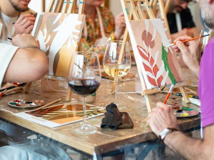 Boston - group working on a red leaf design with a paintbrush and wine glass on the table Shot