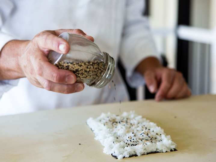 Philadelphia - Chef sprinkling sesame seeds on freshly prepared sushi rice Shot